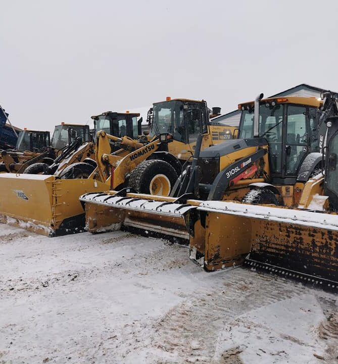 Winter Fleet of Snow Removal Equipment Signature landscape Commercial Snow & Ice Removal Row of snow-covered loaders and plows parked during winter